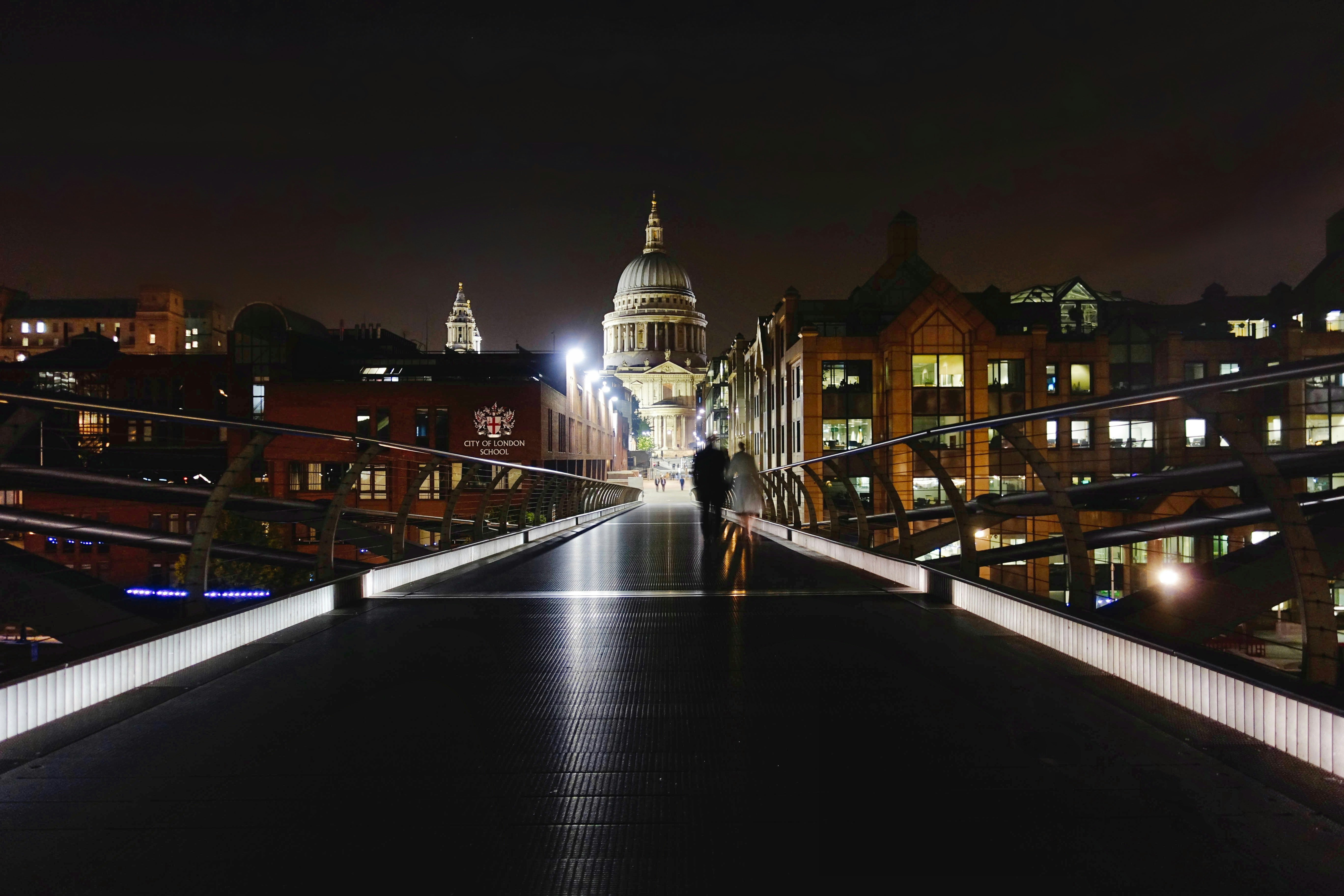 two people walking on bridge during nighttime